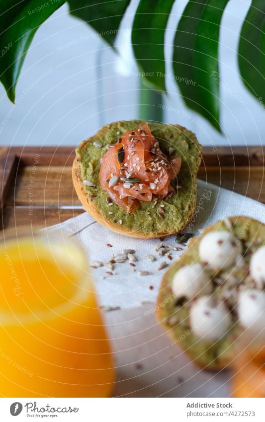 Leckere Avocado-Toasts mit Lachs und Mozzarella, serviert mit kalten Getränken zum Frühstück Zuprosten Saft Tee gesunde Ernährung Mahlzeit geschmackvoll trinken