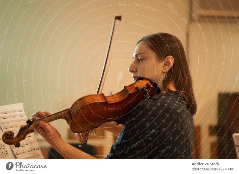 Eine Geigerin spielt klassische Musik in einem Saal Frau Musiker spielen ausführen Probe Instrument Fähigkeit Melodie Klang Talent Atelier akustisch Audio