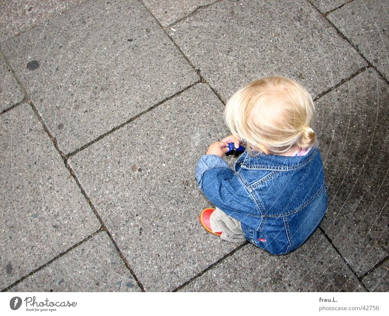 Mia mit Auto Stadtkind Mädchen blond Jeansjacke rot Schuhe hocken Bürgersteig Spielen Kind klein Konzentration niedlich Kleinkind Dinge Verkehrswege Modellauto