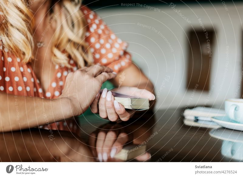 Nahaufnahme der Hände einer Frau mit Tarotkarten in einem Café an einem Tisch habend Kunst Vorhersagen professionell Hellseher psychologisch lesen Erholung