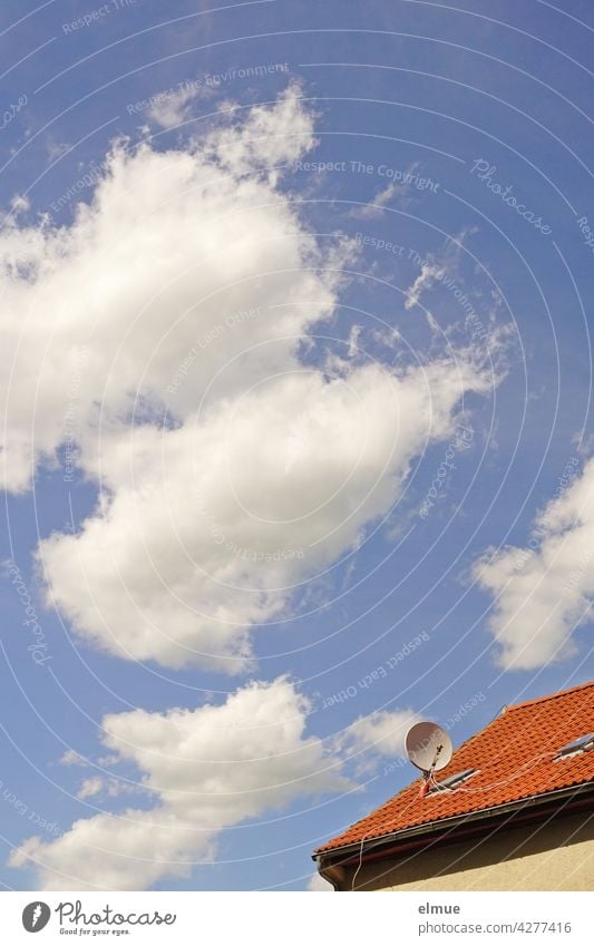 Schönwetterwolken vor blauem Himmel und ein kleiner Ausschnitt von einem roten Ziegeldach mit einer Parabolantenne / Satellitenschüssel / Fußballübertragung