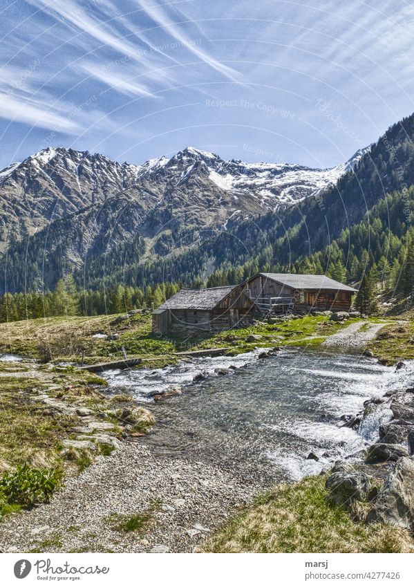 Wandern in den Bergen. Neualm und Obertalbach vor Wasserfallspitze. Almromantik Bergbach Almhütten neues Leben belebend Frühlingserwachen Wolken blau Almwiese