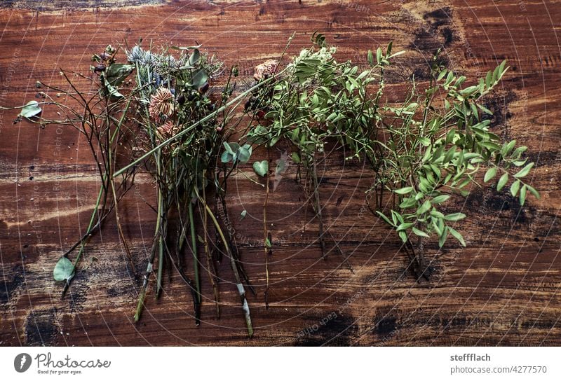 Vertrocknete Blumen und Blätter auf Holztisch Tisch rustikal Farbfoto braun menschenleer Innenaufnahme vertrocknet trocken Trockenblume Trockenblumen verdörrt