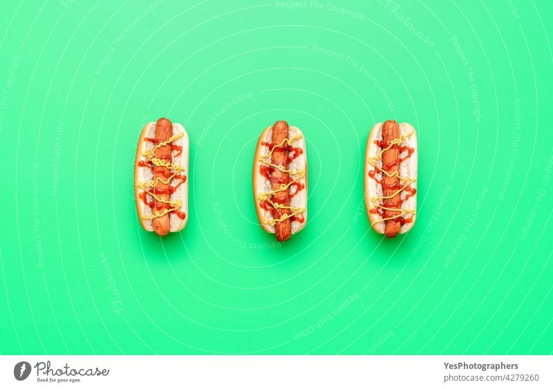 Hot Dogs Draufsicht minimalistisch auf einem grünen Tisch oben Amerikaner Hintergrund Brot Brötchen Kalorien Farbe Textfreiraum Küche ausschneiden lecker essen