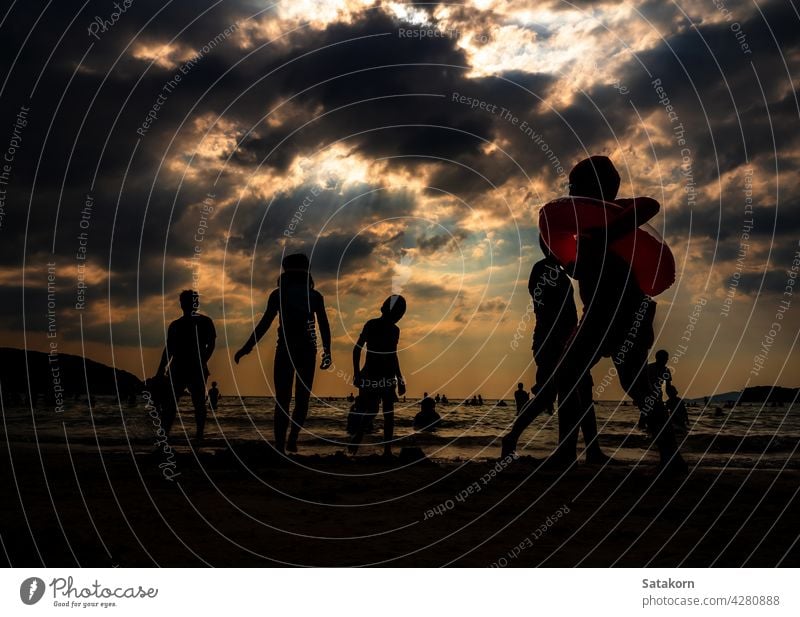 Silhouetten von Menschen spielen im Meer an einem öffentlichen Strand Landschaft Himmel Sand Abend Urlaub MEER Sonne Sonnenuntergang Zusammensein Sommer jung