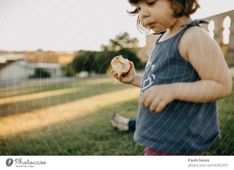 Kind isst frisches Obst Mädchen Essen Frucht Apfel authentisch 1-3 Jahre Bioprodukte Lebensmittel Gesundheit Mensch Außenaufnahme Farbfoto Kindheit Nahaufnahme