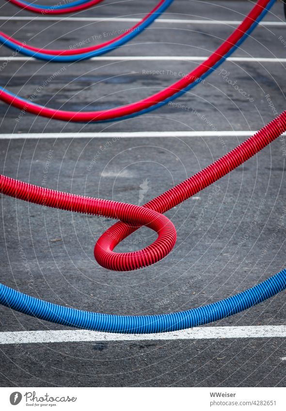 An der Tankstelle kann man das Auto mit Staubsauger und Druckluft reinigen, die Schläuche sind rot und blau Wagen warten pflegen tanken vollmachen Zapfsäule