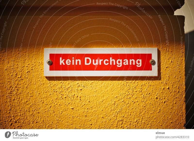 Auf dem auffälligen weiß-roten Schild an einer gelben Wand steht in weißer Druckschrift " kein Durchgang " / Verbot Hinweis gelbe Wand Knallfarben rot-weiß