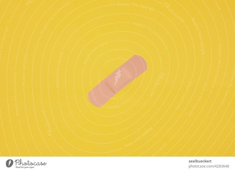 Pflaster oder Heftpflaster auf gelbem Hintergrund Impfung geimpft Verletzung heilen Korona covid-19 COVID Coronavirus Gesundheit Krankheit Gesundheitswesen