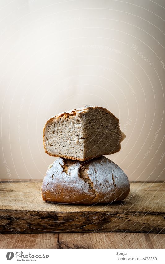 Zwei Brotlaibe gestapelt auf einem Holztisch knusprig gebacken Kruste Tradition selbstgemacht rustikal geschmackvoll frisch Bäckerei Produkt natürlich