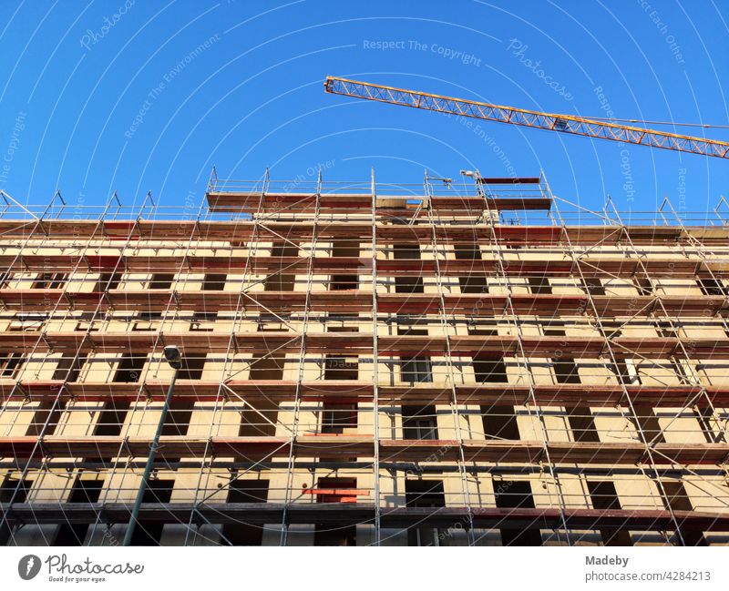 Gebäudekomplex im Rohbau mit Baugerüst zur Schaffung von Wohnraum im Rhein-Main-Gebiet vor blauem Himmel bei Sonnenschein in Offenbach am Main in Hessen