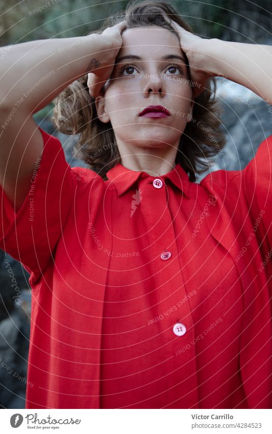 Eine elegante modische frische schöne Frau in einem roten Vintage-Kleid mit Felsen Hintergrund. Porträt Schönheit jung Mode Model Behaarung Gesicht Person