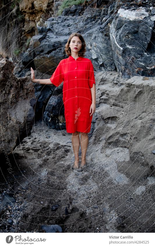 Eine elegante modische frische schöne Frau in einem roten Vintage-Kleid mit Felsen Hintergrund. Porträt Schönheit jung Mode Model Behaarung Gesicht Person