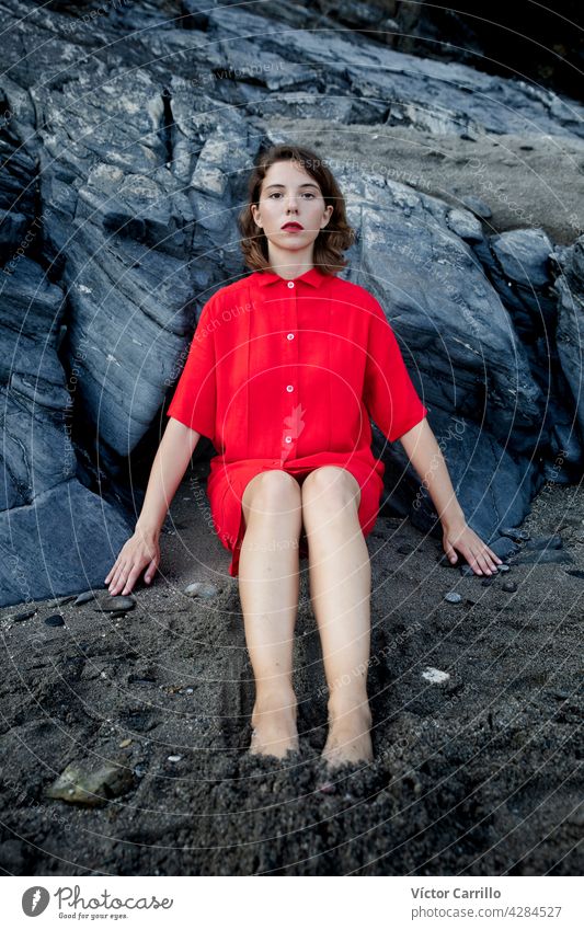 Eine elegante modische frische schöne Frau in einem roten Vintage-Kleid mit Felsen Hintergrund. Porträt Schönheit jung Mode Model Behaarung Gesicht Person