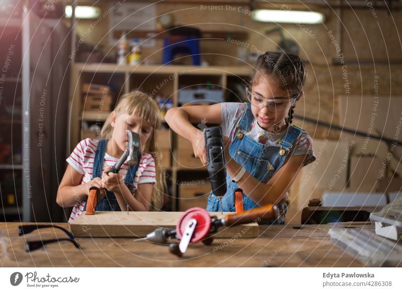 Kinder arbeiten in der Werkstatt Menschen Mädchen Frauenpower Fähigkeit Handwerk Garage Hobby Lifestyle Werkzeuge Konzentration Kreativität Präzision Zimmerer