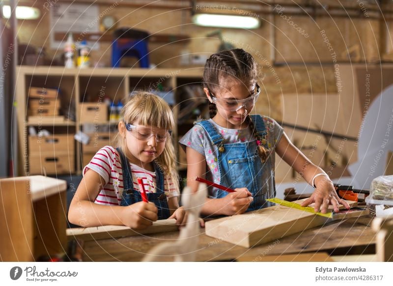 Zwei junge Mädchen bei der Holzarbeit in einer Werkstatt arbeiten Menschen Kind Kinder Frauenpower Fähigkeit Handwerk Garage Hobby Lifestyle Werkzeuge