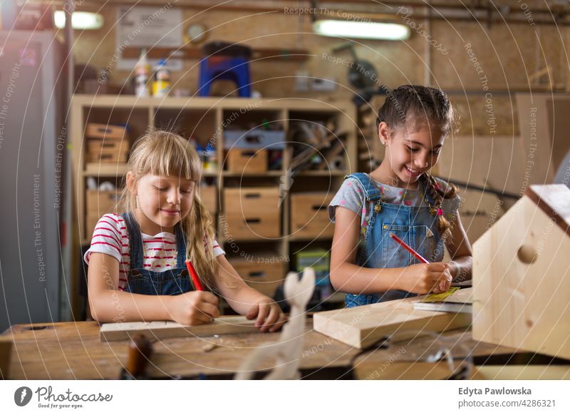 Zwei junge Mädchen bei der Holzarbeit in einer Werkstatt arbeiten Menschen Kind Kinder Frauenpower Fähigkeit Handwerk Garage Hobby Lifestyle Werkzeuge