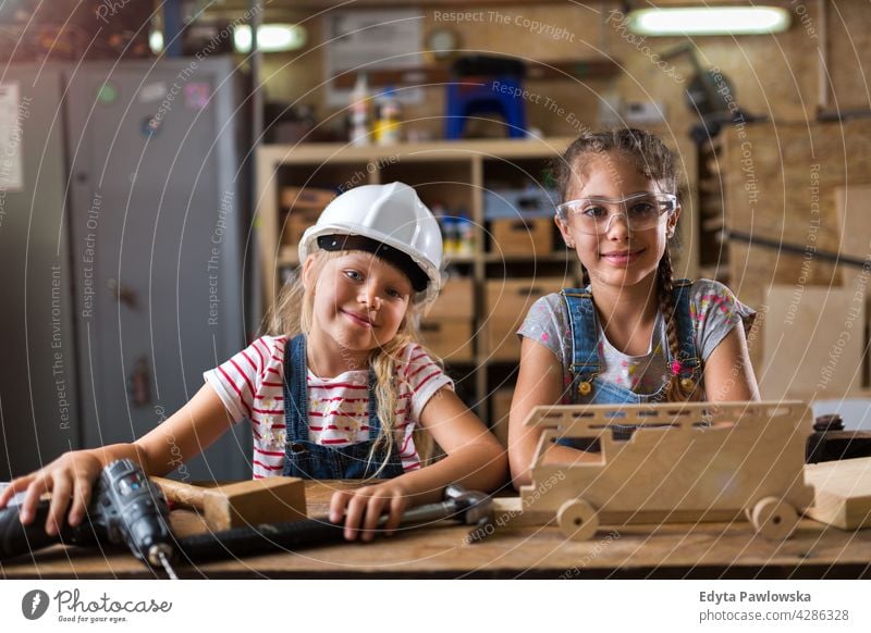 Zwei junge Mädchen bei der Holzarbeit in einer Werkstatt arbeiten Menschen Kind Kinder Frauenpower Fähigkeit Handwerk Garage Hobby Lifestyle Werkzeuge