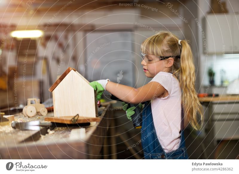 Mädchen baut Vogelhaus in Garage Werkstatt arbeiten Menschen Kind Kinder Frauenpower Fähigkeit Handwerk Hobby Lifestyle Werkzeuge Konzentration Kreativität