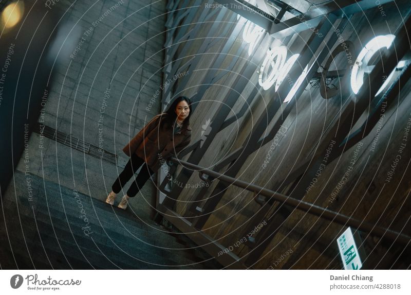 Mädchen unter der Treppe suchen Treppenhaus Porträt Hochformat jung Teenager Blick Stehen Warten Innenbereich Außenseite Straße Licht Stollen Stimmung