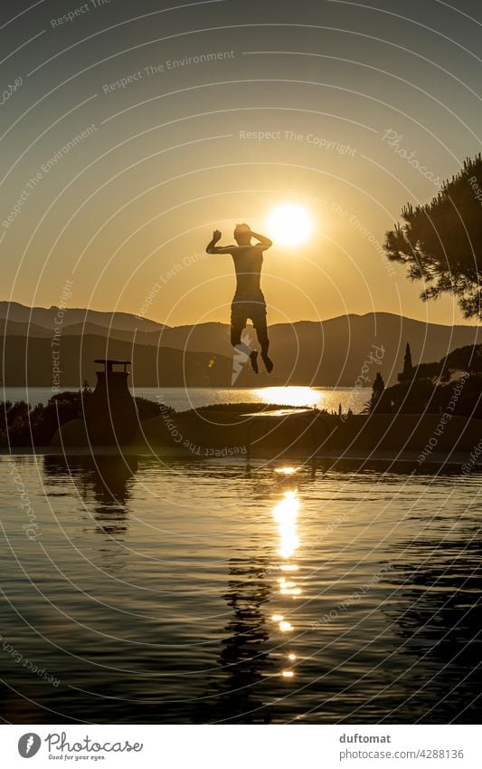 Teenager springt abends von Sprungbrett ins Wasser Abend Sonnenuntergang Pool Junge Gegenlicht Gegenlichtaufnahme Schwimmbad Schwimmen & Baden Freizeit & Hobby