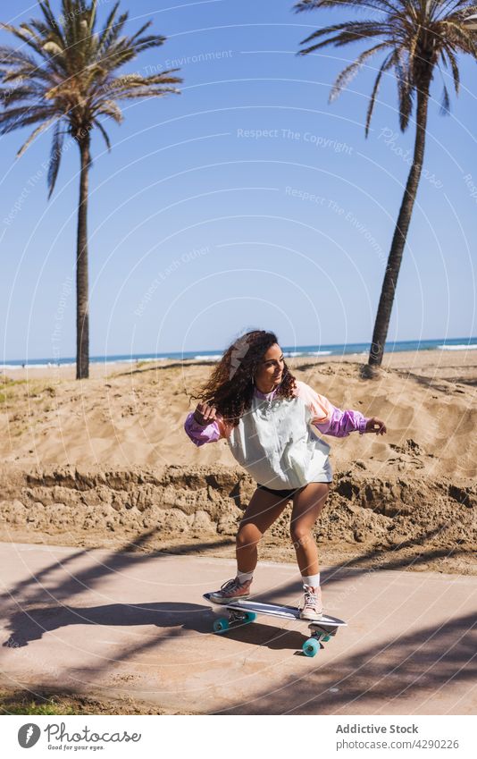 Sportliche Frau auf dem Skateboard am Meer Skateboarderin Mitfahrgelegenheit Hobby Strand Training Küste Stauanlage lässig sportlich jung Übung Aktivität üben