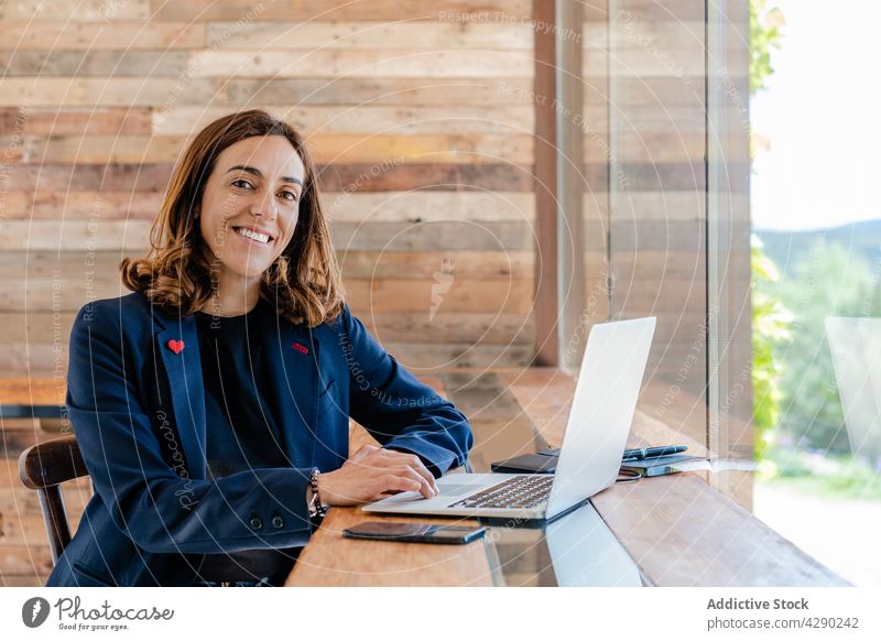 Frau arbeitet per Fernzugriff mit Netbook in einem Café freiberuflich Kantine Tisch modern Stuhl positiv Fenster nachdenklich Erwachsener Laptop selbstbewusst