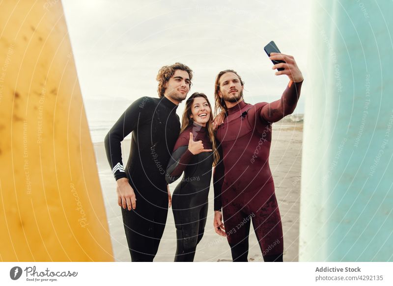 Surferfreunde am Strand mit Surfbrettern machen Selfie mit Handy Sportler Freunde Lächeln Sand Meeresufer Smartphone Aktivität Glück Lifestyle Wasser