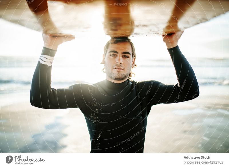 Surfer am Strand mit Surfbrett Mann Natur Sonnenuntergang winken im Freien Porträt Neoprenanzug Meeresküste männlich Brandung Sportler MEER Surfen Hobby tragen