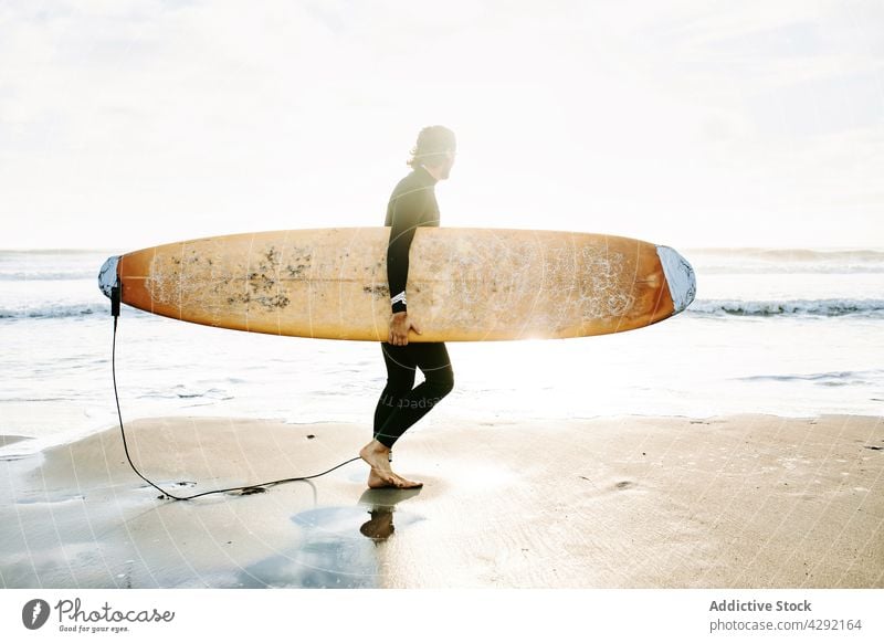 Surfer am Strand mit Surfbrett Mann Natur laufen Sonnenuntergang winken im Freien Neoprenanzug Silhouette Meeresküste männlich Brandung Sportler MEER Surfen