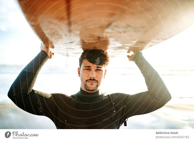 Surfer am Strand mit Surfbrett Mann Natur Sonnenuntergang winken im Freien Porträt Neoprenanzug Meeresküste männlich Brandung Sportler MEER Surfen Hobby tragen