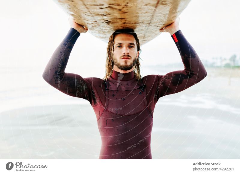 Surfer am Strand mit Surfbrett Mann Natur Sonnenuntergang winken im Freien Porträt Neoprenanzug Meeresküste männlich Brandung Sportler MEER Vollbart lange Haare