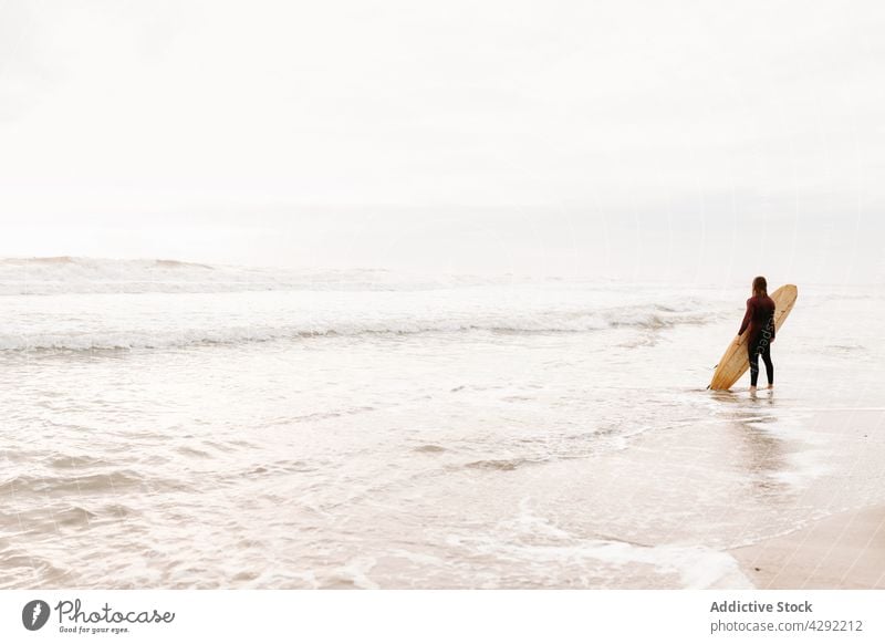 Anonymer Surfer am Strand mit Surfbrett Mann Natur stehen Sonnenuntergang winken im Freien Neoprenanzug Meeresküste männlich Brandung Sportler MEER Surfen Hobby