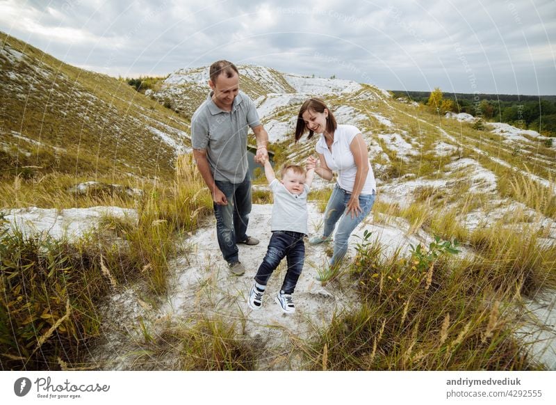 Mama, Papa umarmen Sohn in den Sand Berge genießen und Blick auf die Natur. Junge Familie verbringen Zeit zusammen im Urlaub, im Freien. Das Konzept der Familie Sommerurlaub. Mutter, Vater, Tag des Babys.