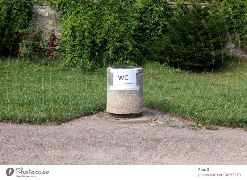 Schilder | provisorisch Park Frühling grün Mauer Weg Gullideckel Papierkorb Beton Hinweisschild Schilder & Markierungen Pfeil Schriftzeichen Buchstaben WC