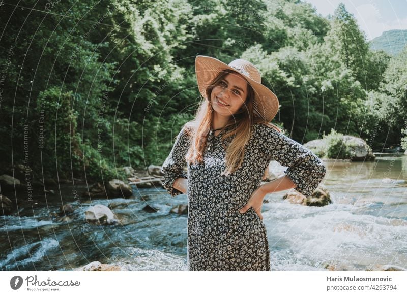 hübsche blonde Frau mit Hut am Fluss in der Natur Accessoire Erwachsener attraktiv weg von der Stadt schön Schönheit Brücke Kaukasier Kleid elegant Gesicht Mode