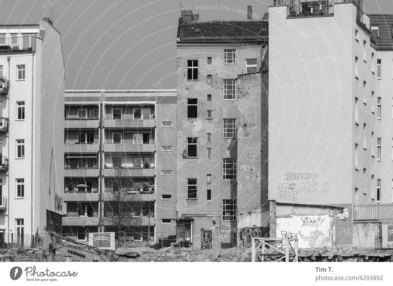 ein Plattenbau , ein Altbauhaus und eine Baustelle Friedrichshain s/w Hinterhof Berlin Stadt Schwarzweißfoto Hauptstadt Bauwerk Altstadt Haus Fenster Fassade