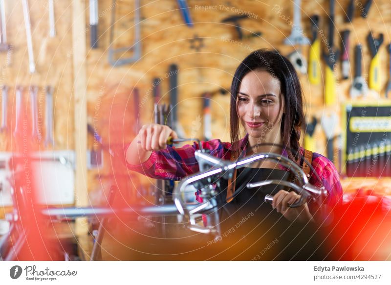 Junge Frau arbeitet in einer Fahrradwerkstatt Vertriebsmitarbeiter Fahrradmechaniker Radfahren Fahrradladen Business Einzelhandel Zyklus hilfreich