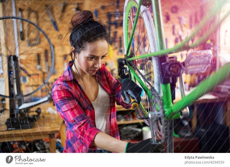 Junge Frau arbeitet in einer Fahrradwerkstatt Vertriebsmitarbeiter Fahrradmechaniker Radfahren Fahrradladen Business Einzelhandel Zyklus hilfreich