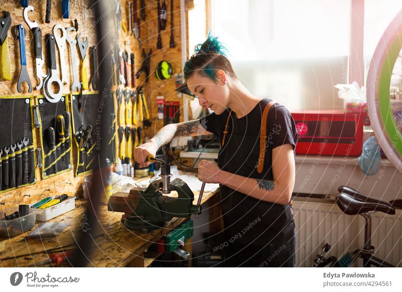 Junge Frau bei der Arbeit in der Werkstatt Vertriebsmitarbeiter Fahrrad Fahrradmechaniker Radfahren Fahrradladen Business Einzelhandel Zyklus hilfreich