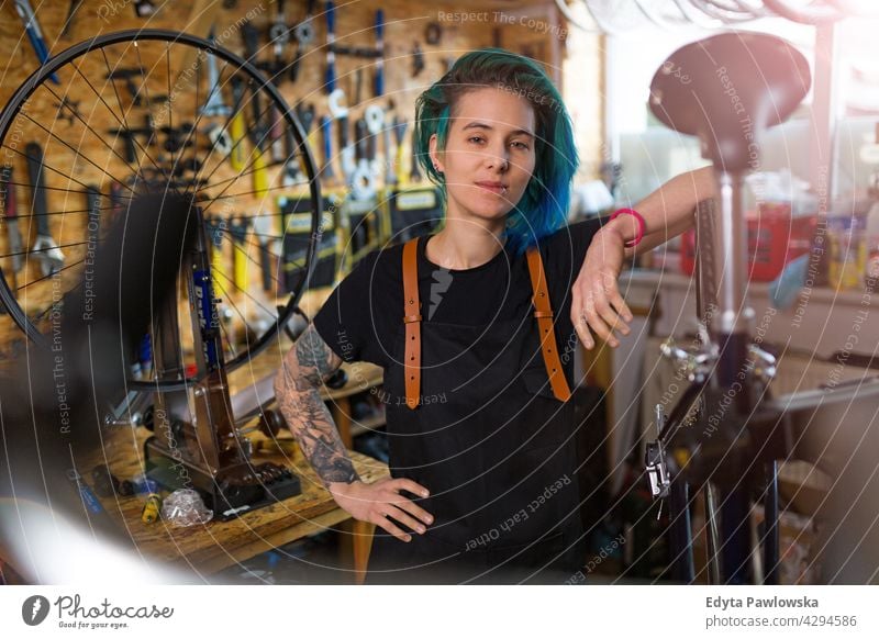 Junge Frau arbeitet in einer Fahrradwerkstatt Vertriebsmitarbeiter Fahrradmechaniker Radfahren Fahrradladen Business Einzelhandel Zyklus hilfreich