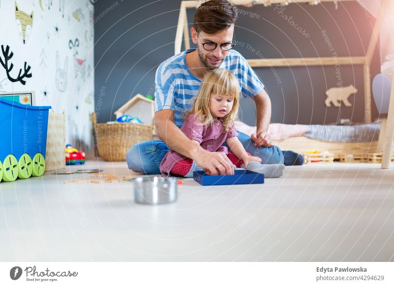 Vater spielt mit Tochter zu Hause heimwärts Mann Papa Familie Eltern Verwandte Kind Mädchen kleines Mädchen Kinder Partnerschaft Zusammensein