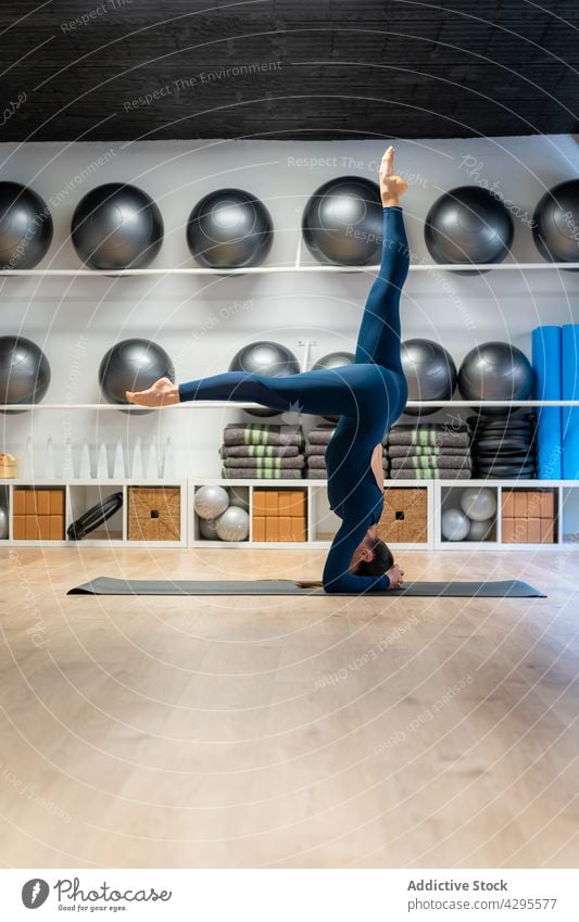 Frau macht Kopfstand während einer Yogastunde Salamba sirsasana Gleichgewicht Umkehrung Asana Pose fortgeschritten Variation Achtsamkeit üben positionieren Zen