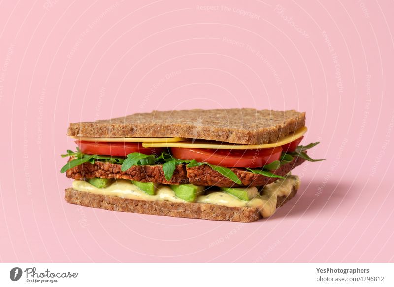 Veganes Sandwich Nahaufnahme isoliert auf einem rosa Hintergrund. alternativ Rucola Avocado Erkenntnis Brot Frühstück Burger Käse Sauberkeit Farbe