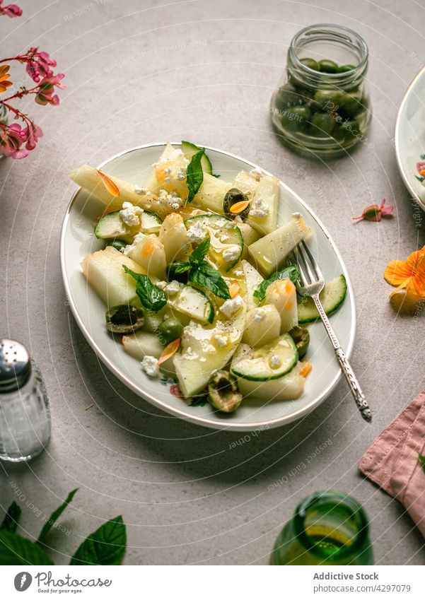 Melonensalat mit Essiggurken und Oliven Salatbeilage gesunde Ernährung Diät Veganer dienen Tisch Salatgurke oliv Kraut Serviette Salz Schüttler Teller organisch