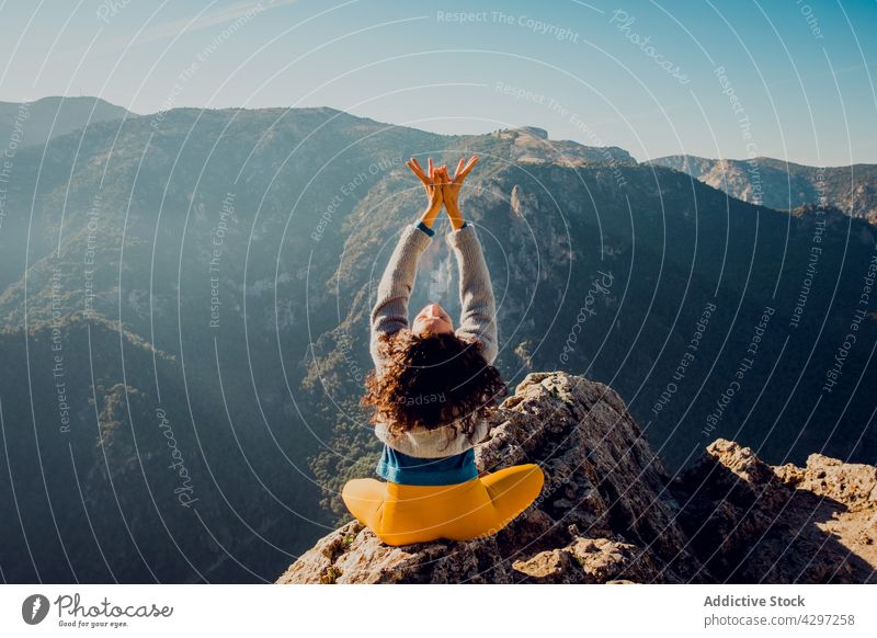 Unbekannter Reisender meditiert in Lotus-Pose in den Bergen Frau Yoga Berge u. Gebirge padmasana üben meditieren Hochland Asana Natur ruhig friedlich Felsen Zen