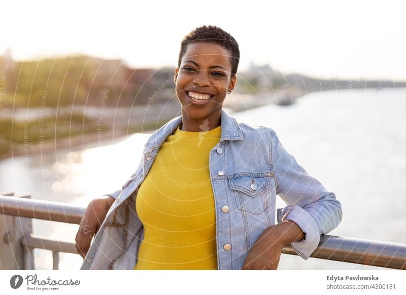 Porträt einer schönen glücklichen Frau im Freien Afro-Look stolz echte Menschen Stadtleben Afroamerikaner Afrikanisch Schüler schwarz Ethnizität sonnig