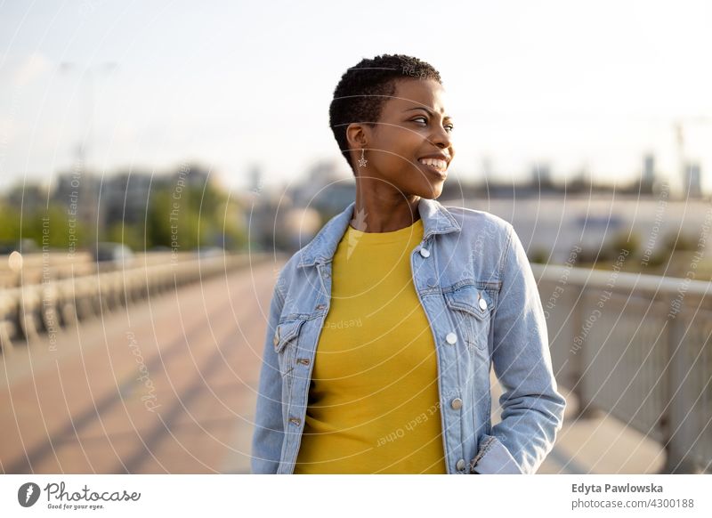 Porträt einer lächelnden jungen Frau in der Stadt Afro-Look stolz echte Menschen Stadtleben Afroamerikaner Afrikanisch Schüler schwarz Ethnizität sonnig