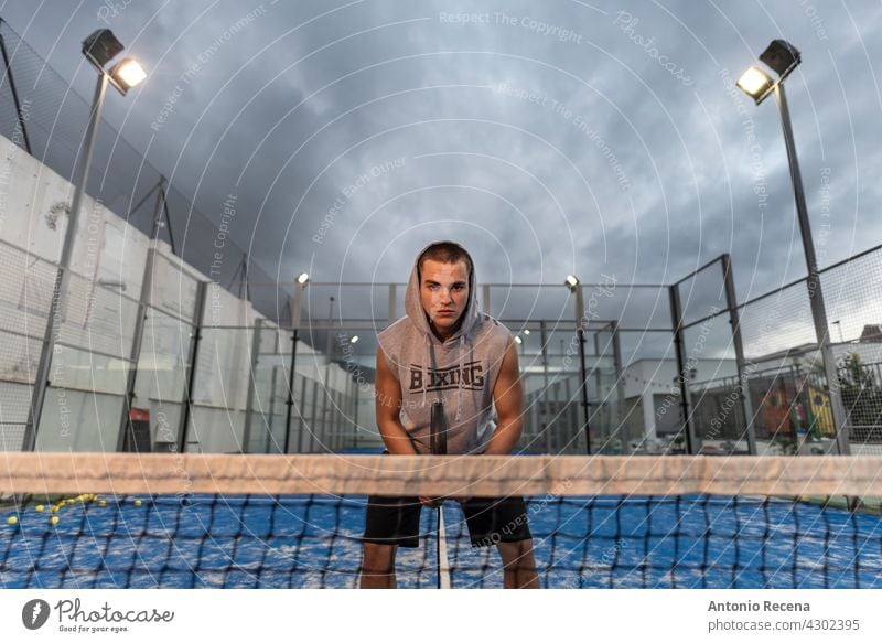 Junger Mann mit urbanen Stil Züge spielen Duell auf einem Platz im Freien jung Training Paddeltennis Padel Gericht Sport Ball Remmidemmi Netz Erholung Rasen