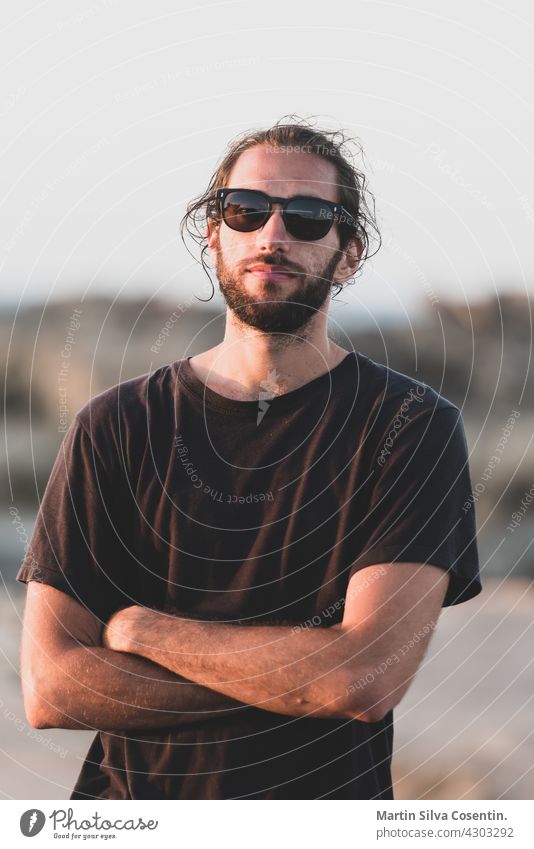 Junger Mann auf dem Pier von Es Calo de Sant Aug den Baleareninseln im Mittelmeer in Es Calo, Formentera, Spanien. Hintergrund Strand schön Schönheit blau Boot